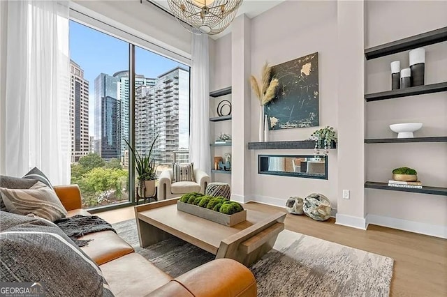 living area featuring built in shelves, a chandelier, and light hardwood / wood-style flooring