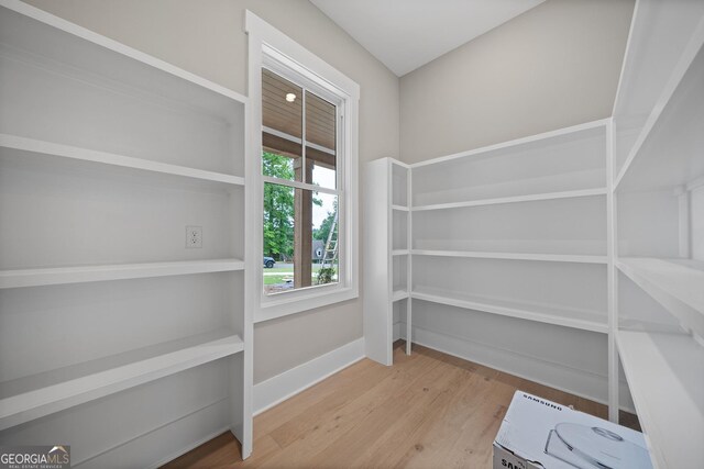 interior space with a notable chandelier, crown molding, and light wood-type flooring