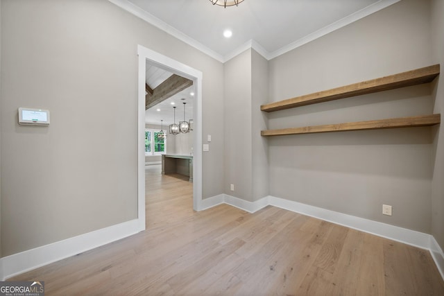 unfurnished dining area featuring light wood-type flooring, baseboards, ornamental molding, and a chandelier