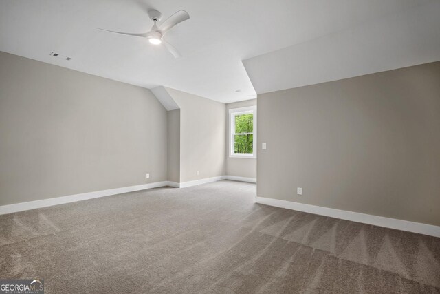 unfurnished bedroom featuring light carpet, ensuite bath, and ceiling fan