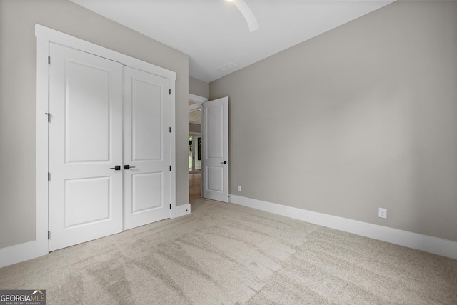 unfurnished bedroom with a closet, a ceiling fan, baseboards, and carpet floors