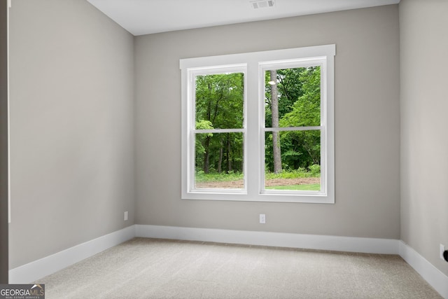 unfurnished room with a wealth of natural light, baseboards, and carpet floors