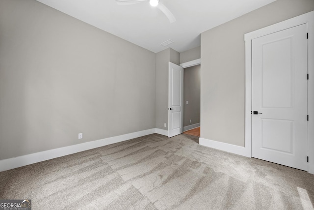 unfurnished bedroom with baseboards, carpet floors, visible vents, and ceiling fan