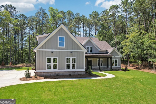 modern farmhouse with a front yard, a standing seam roof, a shingled roof, brick siding, and metal roof