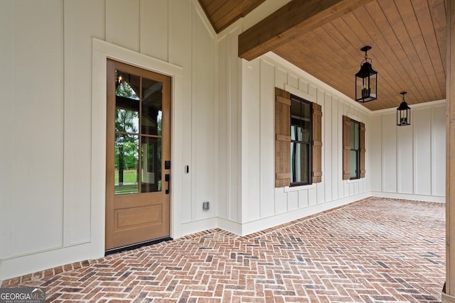 view of exterior entry featuring covered porch and board and batten siding