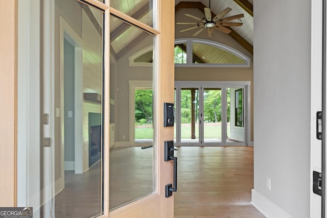 entryway featuring lofted ceiling with beams, baseboards, wood finished floors, and a ceiling fan