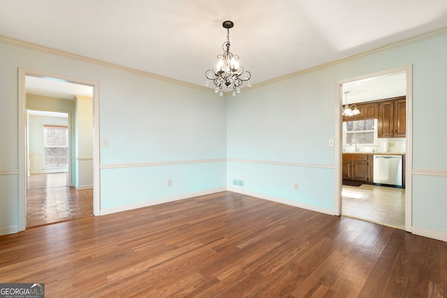 empty room with an inviting chandelier, sink, ornamental molding, and light wood-type flooring