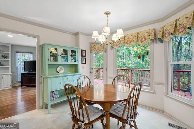 dining space with ornamental molding and a chandelier