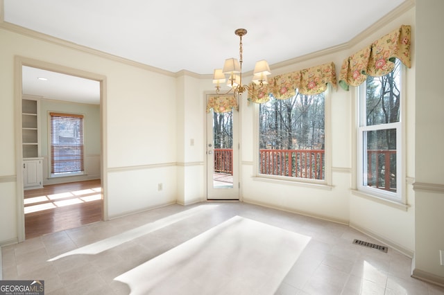 unfurnished dining area with crown molding, light tile patterned floors, and a chandelier