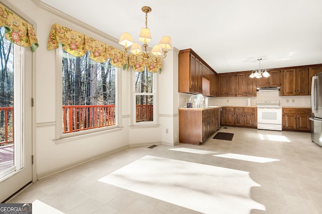 kitchen featuring pendant lighting, a notable chandelier, stainless steel refrigerator, and white range with electric stovetop