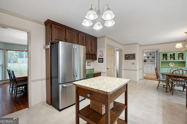 kitchen featuring crown molding, dark brown cabinets, stainless steel refrigerator, and a chandelier