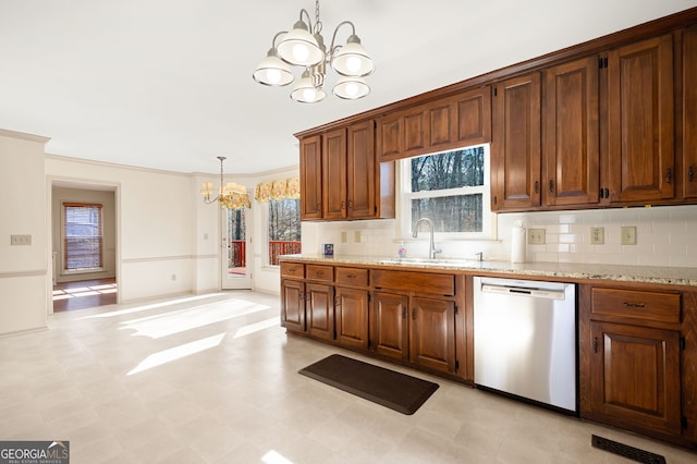 kitchen with pendant lighting, tasteful backsplash, dishwasher, sink, and a notable chandelier