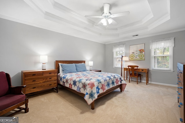 bedroom featuring ceiling fan, ornamental molding, a tray ceiling, and light colored carpet