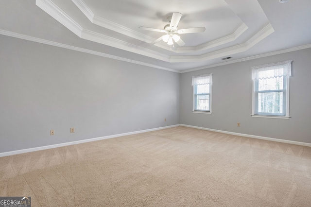 carpeted empty room featuring crown molding, ceiling fan, and a tray ceiling