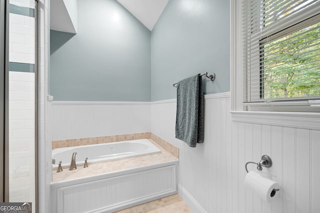 bathroom featuring lofted ceiling and a bath