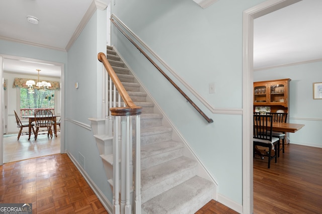 stairway with ornamental molding and a notable chandelier