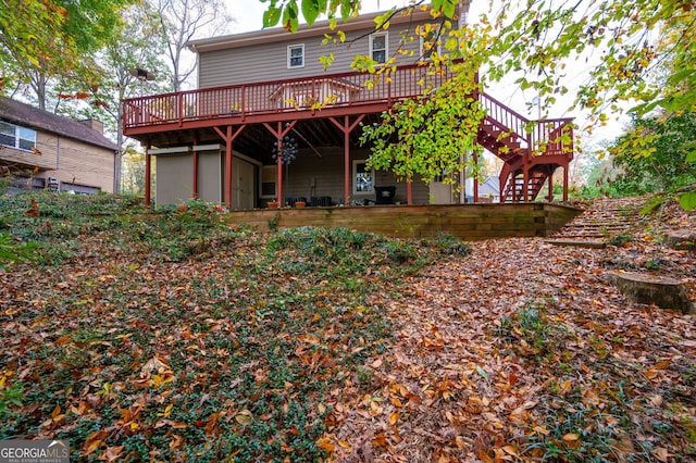 rear view of house featuring a wooden deck