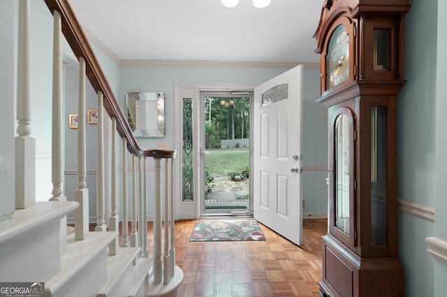 foyer with light parquet floors and ornamental molding