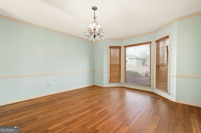 unfurnished room featuring a notable chandelier, crown molding, and wood-type flooring