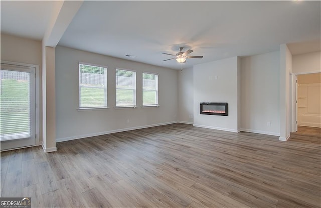 unfurnished living room featuring ceiling fan and light wood-type flooring