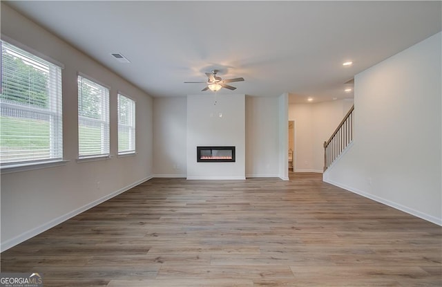 unfurnished living room with ceiling fan and light hardwood / wood-style floors