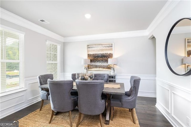 dining area with ornamental molding and dark hardwood / wood-style floors