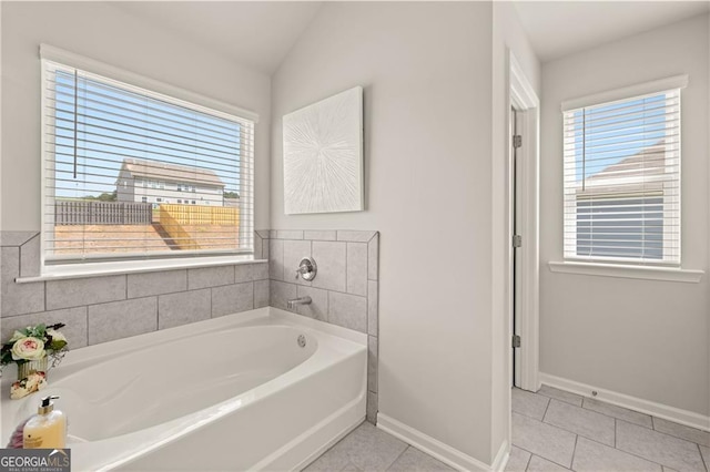 bathroom with tile patterned floors, lofted ceiling, and a bathing tub