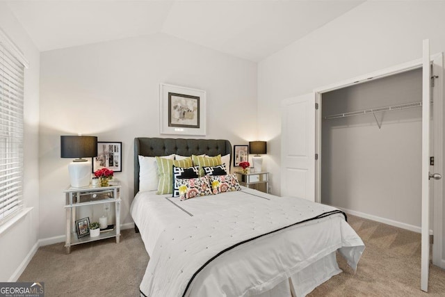 bedroom with lofted ceiling, light carpet, and a closet