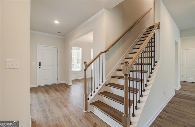 foyer featuring crown molding and wood-type flooring