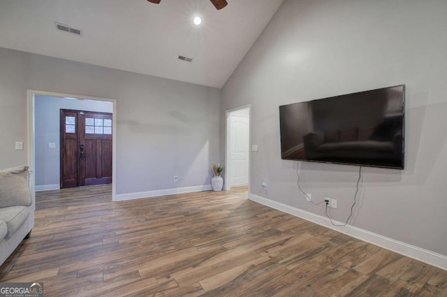 unfurnished living room featuring wood-type flooring, high vaulted ceiling, and ceiling fan