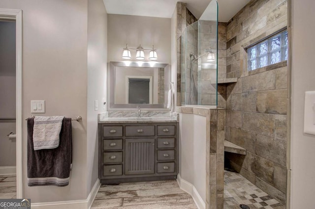 bathroom with vanity, wood-type flooring, and a tile shower