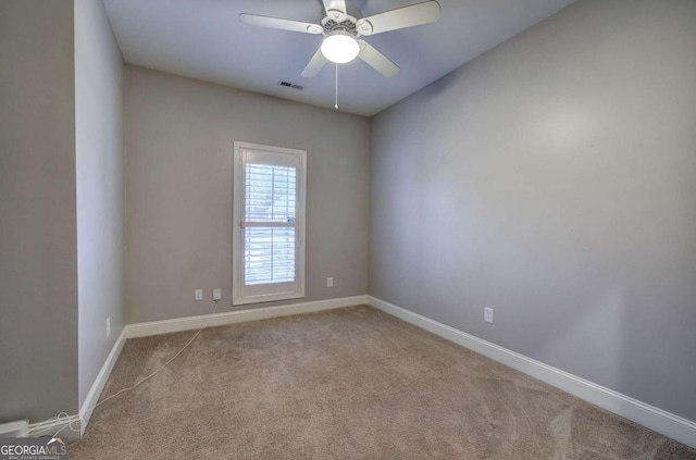 spare room with ceiling fan and light colored carpet