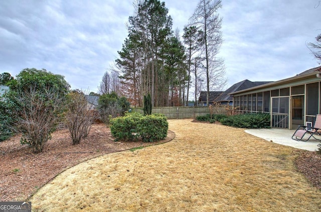 view of yard with a sunroom and a patio area