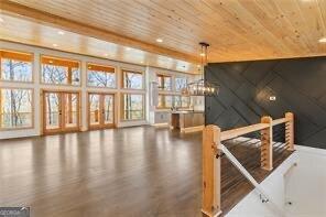 bonus room featuring wood-type flooring, a notable chandelier, and wood ceiling