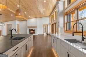 kitchen featuring white cabinetry, sink, and hanging light fixtures