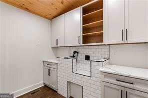 interior space with white cabinetry, wood ceiling, dark hardwood / wood-style flooring, and light stone countertops