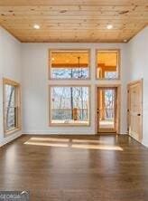 unfurnished living room featuring a high ceiling, dark wood-type flooring, and wood ceiling