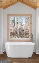 bathroom featuring a bathing tub, lofted ceiling, wood-type flooring, and wood ceiling