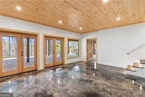 unfurnished living room with wooden ceiling and french doors