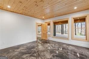 spare room with wood ceiling and concrete floors