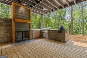 wooden terrace featuring grilling area and exterior kitchen