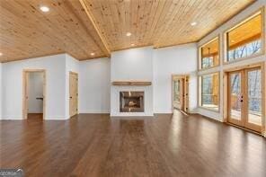 unfurnished living room with wood ceiling, dark wood-type flooring, french doors, and a high ceiling