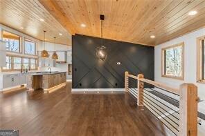 interior space with pendant lighting, wood ceiling, and dark wood-type flooring