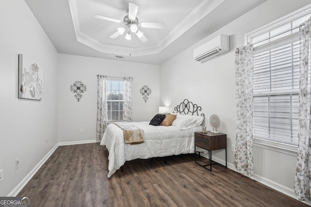 bedroom with crown molding, ceiling fan, dark hardwood / wood-style floors, a wall mounted AC, and a tray ceiling