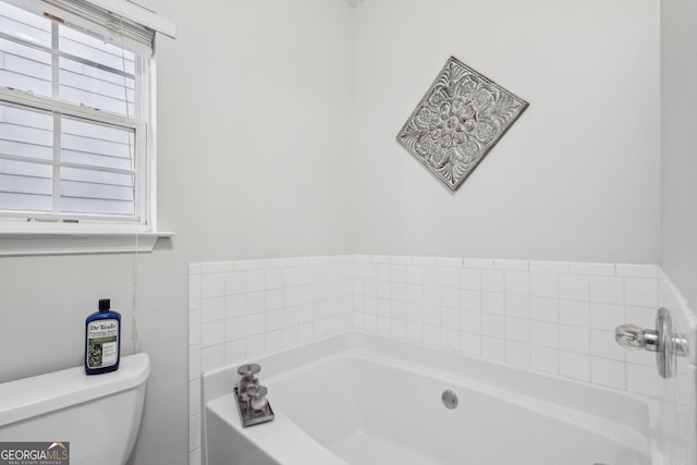 bathroom with toilet and a tub to relax in