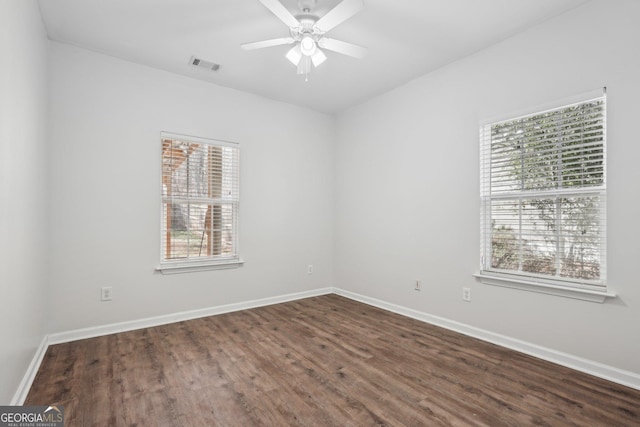 empty room with dark hardwood / wood-style floors and ceiling fan