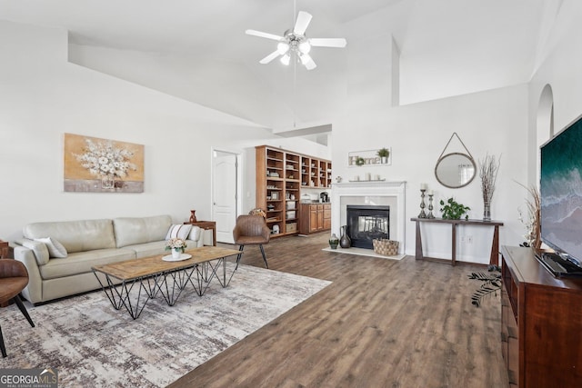 living room with hardwood / wood-style flooring, ceiling fan, and high vaulted ceiling