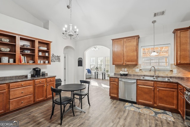 kitchen with vaulted ceiling, pendant lighting, sink, dark hardwood / wood-style flooring, and stainless steel appliances