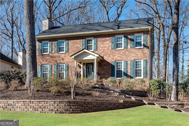 colonial home featuring a front lawn