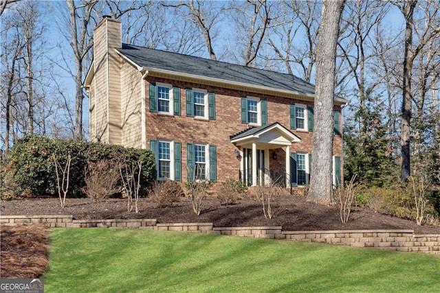 colonial inspired home featuring a front lawn